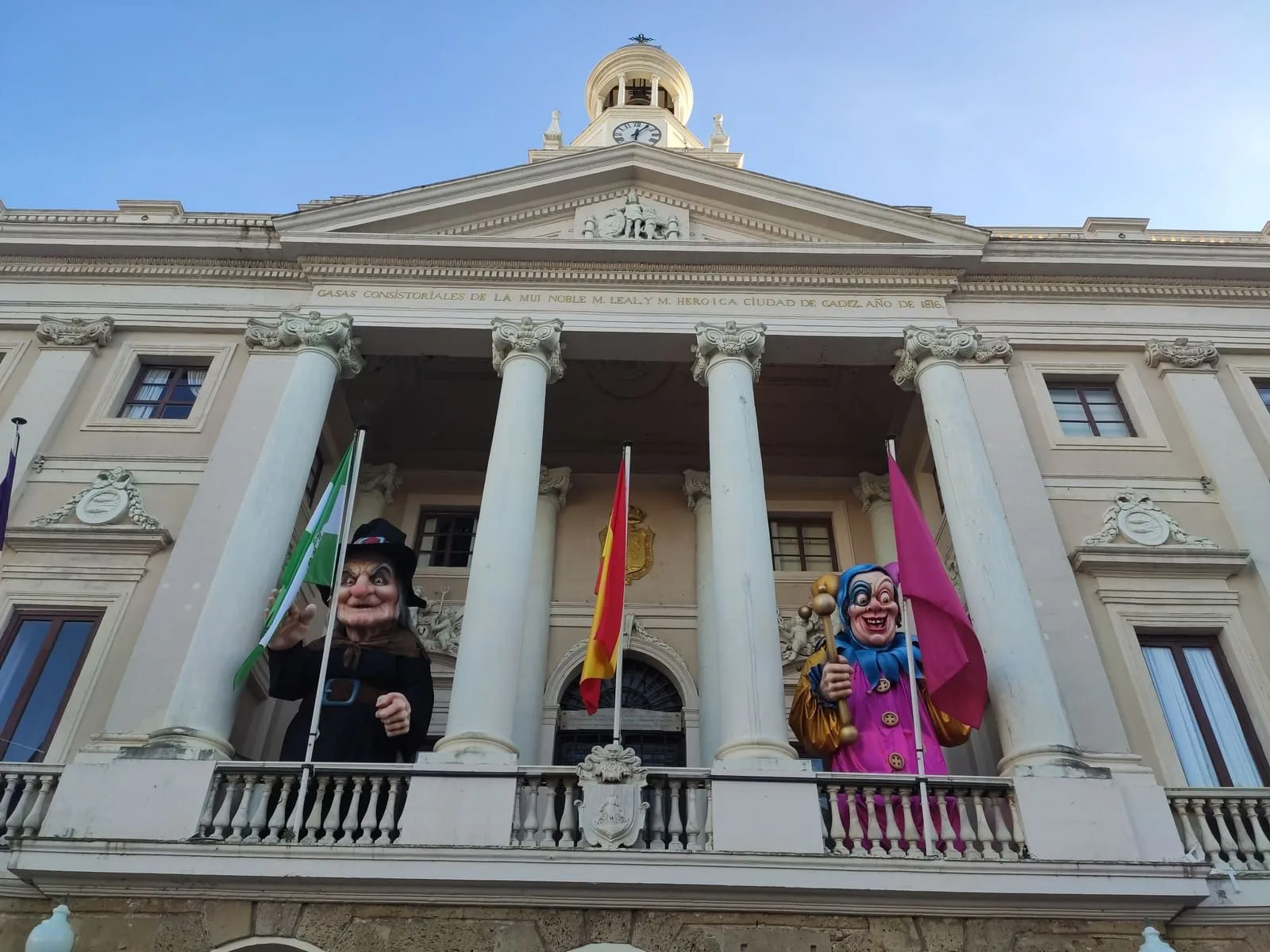 Figura 2. Figuras de la Bruja Piti, a la izquierda, y el Dios Momo, a la derecha, en el balcón del Ayuntamiento de Cádiz (Cádiz, 2020). Fotografía propia.
