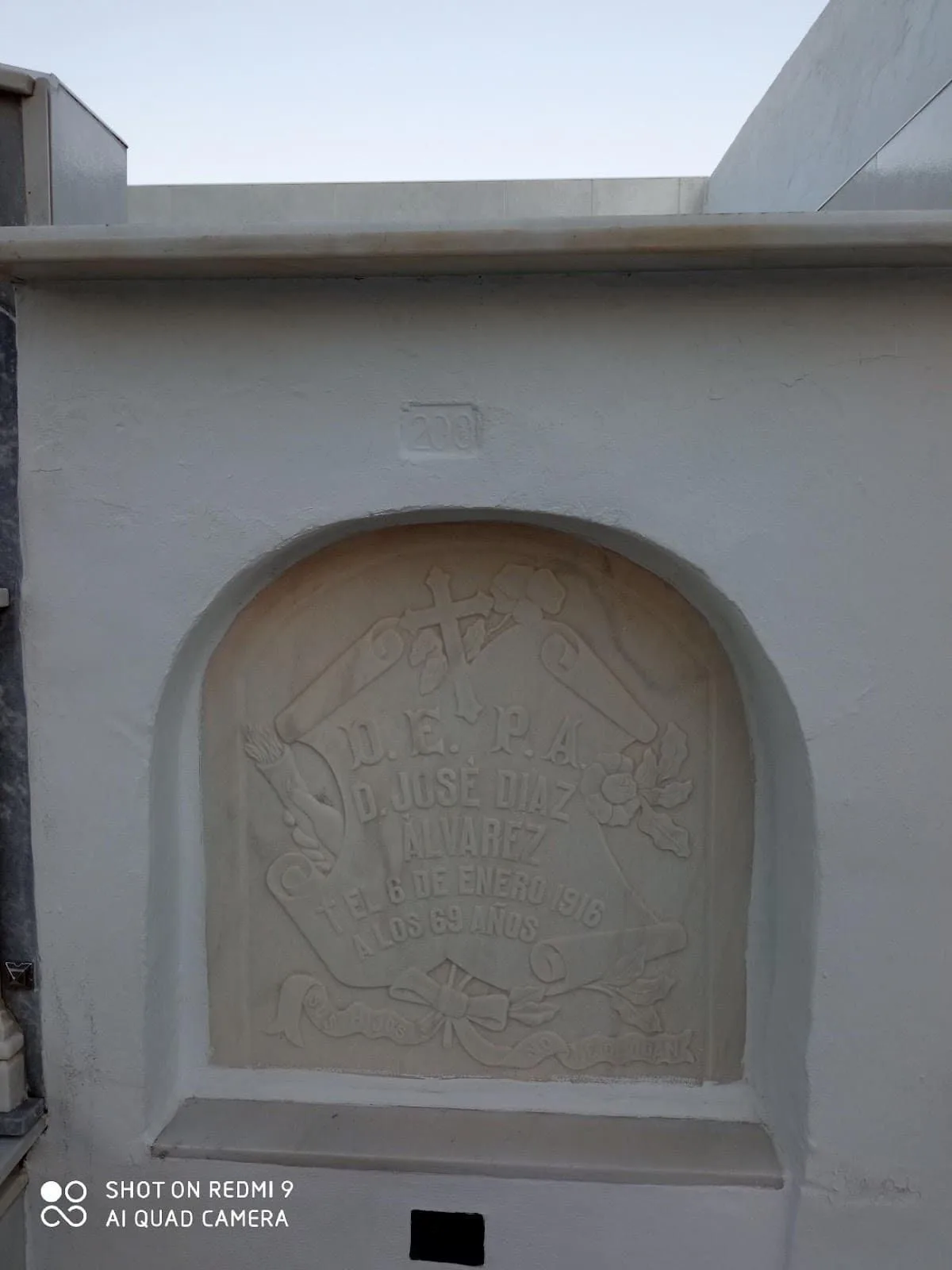 Figura 2. Detalle a la izquierda de la lápida, asomando detrás del pergamino una mano con una antorcha en un nicho de un individuo adscrito a una logia masónica, situada en el Cementerio Municipal de Herrera (Sevilla). Fuente: el autor.