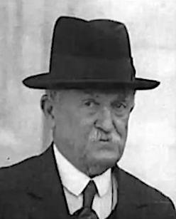 Foto en blanco y negro de un hombre con traje y sombrero

Descripción generada automáticamente