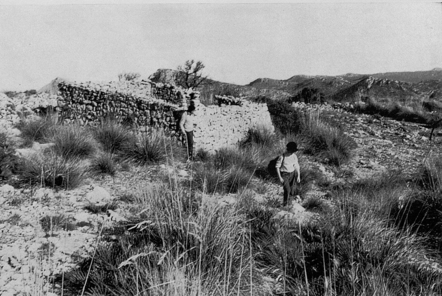 A couple of people walking on a dirt path

Description automatically generated